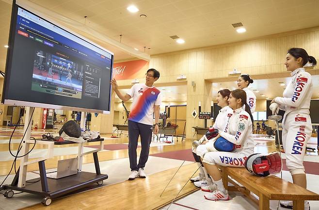 여자 펜싱 에페 국가대표팀 선수들과 함재만 코치가 SKT의 펜싱 AI 전력 분석 시스템 SKT-FAN을 활용해 전력 분석을 하고 있다. 함재만(왼쪽부터) 코치, 임태의, 양승혜, 송세라, 이혜인 선수 등. [SK텔레콤 제공]
