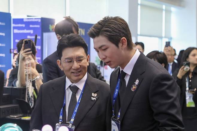 지난해 10월 29일 경주 예술의전당에서 열린 'APEC CEO 서밋' 개회식에서 방시혁 하이브 의장과 방탄소년단 RM이 하이브 홍보부스를 관람하고 있다. 2025.10.29 /하이브 제공