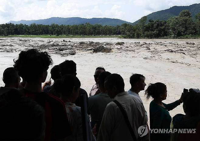 100km 너머까지 이어진 거센 흙탕물 (치트완[네팔]=연합뉴스) 김성민 기자 = 네팔과 중국 국경 히말라야 산악지대에서 발생한 대규모 홍수 수습이 이어지고 있는 30일(현지시간) 최초 사고 지점에서 100여km 떨어진 치트완 나라야니 강가에서 시민들이 흙탕물을 바라보고 있다. 2026.8.30 ksm7976@yna.co.kr