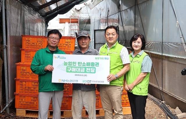 임세빈(왼쪽 세번째) NH농협은행 수석부행장과 이석형(왼쪽 첫번째) 한국농업기술진흥원 원장이 지난 2일 제주특별자치도 서귀포시 소재 농가를 방문해 ‘농업부문 탄소배출권 구매대금 전달식’을 갖고 기념촬영을 하고 있다. [농협은행 제공]
