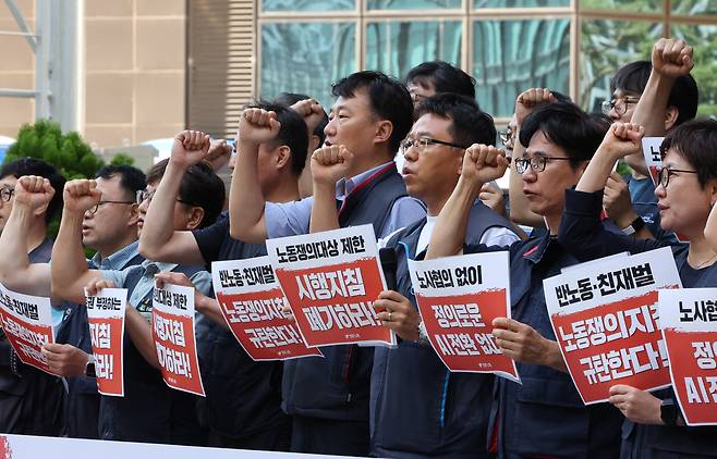 민주노총 소속회원들이 4일 서울 중구 서울고용노동청 앞에서 고용노동부의 ‘경영성과급 등 노동쟁의 대상 시행지침’ 규탄 기자회견을 하고 있다. 고용노동부는 전날 노동조합의 ‘영업이익 N% 성과급 요구’나 ‘호남 반도체 공장 신설 반대’ 등은 의무적 교섭대상 및 조정·쟁의행위 대상이 될 수 없다는 시행지침을 발표했다.  [연합]