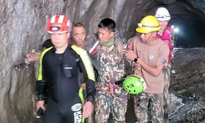 네팔과 티베트 산악지대를 휩쓴 대홍수 발생 열흘째인 5일(현지시간) 네팔 라수와 지역 어퍼댐 인근 터널에서 네팔과 한국 합동구호대가 중국인 생존자 1명을 구조하고 있다. 외교부 제공