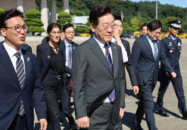 프랑스를 국빈방문하는 이재명 대통령이 지난 9월 6일 성남 서울공항에서 환송나온 김민석(왼쪽) 더불어민주당 신임 당대표, 참모진 등과 함께 공군 1호기로 이동하고 있다. [연합뉴스]