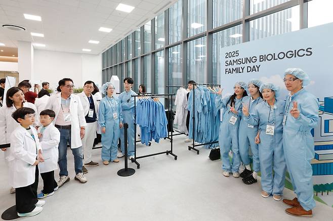 인천 송도국제도시에서 열린 ‘2025 삼성바이오로직스 가족초청행사’에 참석한 임직원과 가족들이 가운 입기 체험을 진행하고 있다. [삼성바이오로직스 제공]