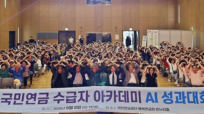 전북 전주 국민연금공단 온누리홀에서 열린 ‘국민연금 수급자 아카데미 AI 성과대회’에서 수급자 등 참석자들이 두 팔을 들어 하트를 만들어 보이고 있다. 국민연금나눔재단 제공