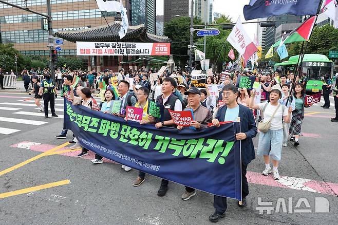 [서울=뉴시스] 황준선 기자 = 12일 서울 종로구 세종대로 사거리 인근에서 열린 '미국은 침략전쟁 중단하라! 정부는 호르무즈 파병 단호히 거부하라! 시민 대행진'에서 참석자들이 청와대를 향해 행진하고 있다. 2026.09.12. hwang@newsis.com