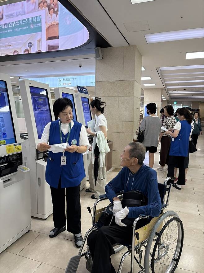 무인수납 안내원 신정희씨가 도움을 요청하는 환자에게 응대를 하고 있다. 남궁인 작가 제공