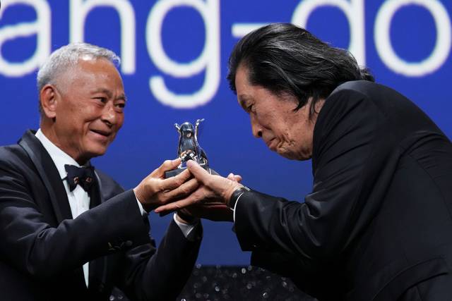 Jury member Johnnie To, left, presents director Lee Chang-dong the grand jury prize for the film ‘Possible Love’ during the closing ceremony of the 83rd edition of the Venice Film Festival in Venice, Italy, on Saturday, Sept. 12, 2026. (Photo by Scott A Garfitt/Invision/AP) 090226133139