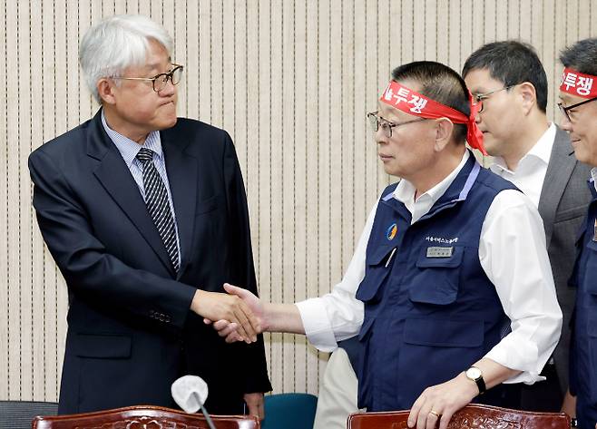 김정환(왼쪽) 서울시버스운송사업조합 이사장과 박점곤 전국자동차노동조합연맹 서울시버스노동조합 위원장이 15일 서울 영등포구 서울지방노동위원회에서 열린 서울시내버스 노사 2차조정회의에서 악수하고 있다. /사진=뉴시스