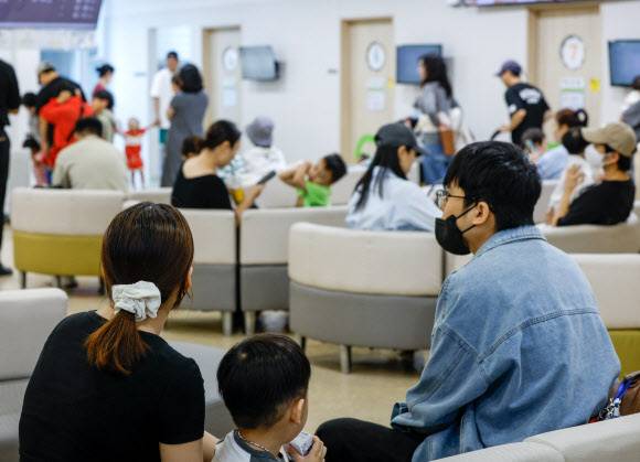 환절기 독감이나 폐렴 등 호흡기 질환 환자가 늘어나는 가운데 지난 14일 서울의 한 소아청소년과 병원에서 아이와 부모들이 진료를 기다리고 있다. 최성수 기자