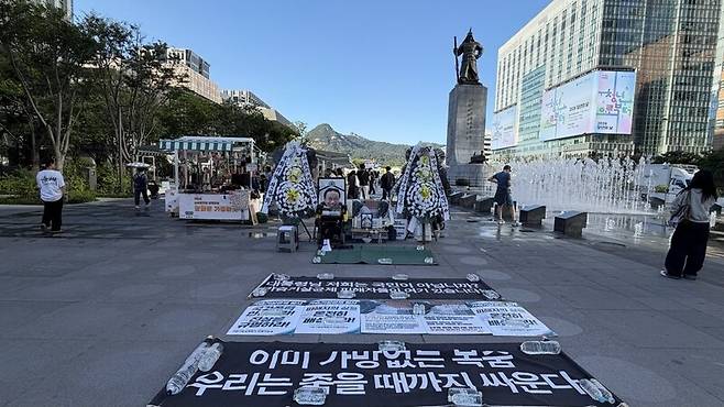 지난 16일 서울 광화문광장에 마련된 고 서영철 가습기살균제대참사피해자연대 회장의 빈소를 이순신 장군상이 내려다보고 있다. 류이 감독 제공