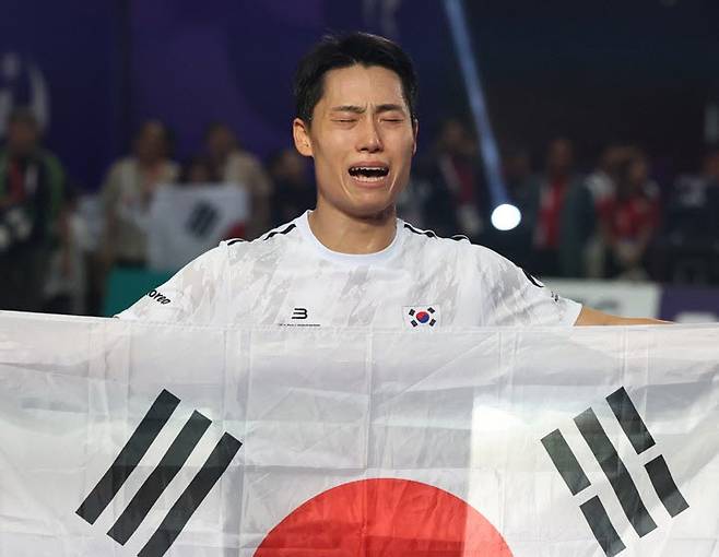 20일 일본 나고야 히가시 스포츠센터에서 열린 2026 아이치·나고야 아시안게임 테크볼 남자 단식 결승전에서 이라크 알리 자릴 메제르 알엘라야위에게 승리해 금메달을 획득한 이준석이 태극기를 들고 기쁨의 눈물을 흘리고 있다. 사진=연합뉴스
