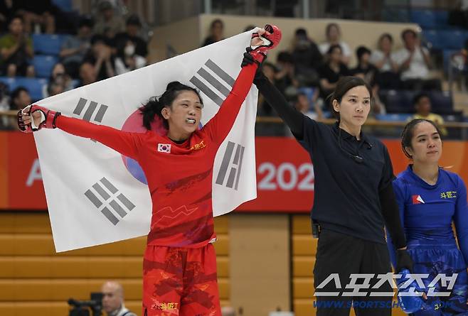 이보미가 20일 열린 MMA 여자 모던 -54kg급 8강전서 승리해 동메달을 확보한 뒤 태극기를 펼치며 기뻐하고 있다. 사진=AMMA