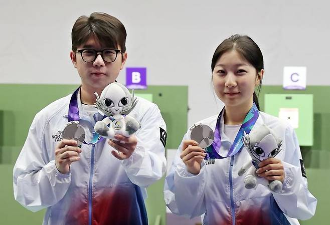 22일 일본 아이치현 종합 사격장에서 열린 2026 아이치·나고야 아시안게임 사격 10m 공기소총 혼성 단체전 시상식에서 은메달을 차지한 한국 반효진(오른쪽)과 박하준이 메달을 들어보이고 있다.ⓒ연합뉴스