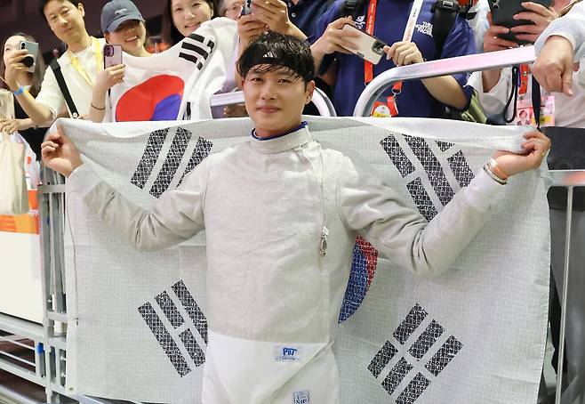 23일 일본 아이치현 도코나메 아이치 스카이 엑스포에서 열린 2026 아이치·나고야 아시안게임 남자 사브르 개인전 결승 경기. 한국 오상욱이 중국의 선천펑을 상대로 승리하고 금메달을 차지한 뒤 태극기를 펼쳐들고 있다. 연합뉴스