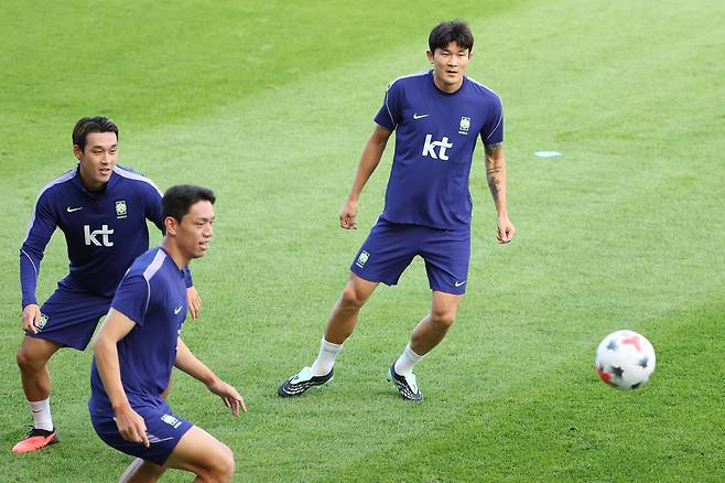 축구대표팀 수비의 핵 김민재(오른쪽)가 22일 충남 천안시 코리아풋볼파크에서 열린 공개훈련에서 패스 주고받기를 하며 몸을 풀고 있다. 연합뉴스