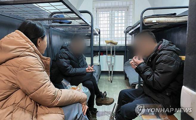 우크라이나군에 생포된 북한군 포로 (서울=연합뉴스) 우크라이나군에 생포된 북한군 포로 백모씨와 리모씨가 28일(현지시간) 우크라이나 내 포로수용소에서 김영미PD와 접견하며 탈북민단체들이 보낸 북한음식 '두부밥'을 먹고 있다. 침대(왼쪽 상단)에 이들이 직접 그린 김정은 북한 국무위원장의 초상화가 붙어 있다. 2025.10.31 [겨레얼통일연대 제공. 재판매 및 DB금지] photo@yna.co.kr