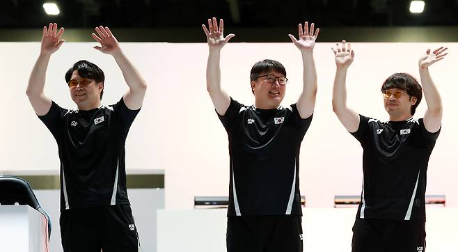 한국 e스포츠 대표팀 연제길(왼쪽부터), 이광노, 배재민이 26일 일본 아이치현 도코나메시 아이치 스카이 엑스포에서 열린 2026 아이치·나고야 아시안게임 e스포츠 대전격투 결승에서 일본을 꺾고 금메달을 획득한 뒤 두 팔을 들고 기뻐하고 있다. 도코나메=뉴시스