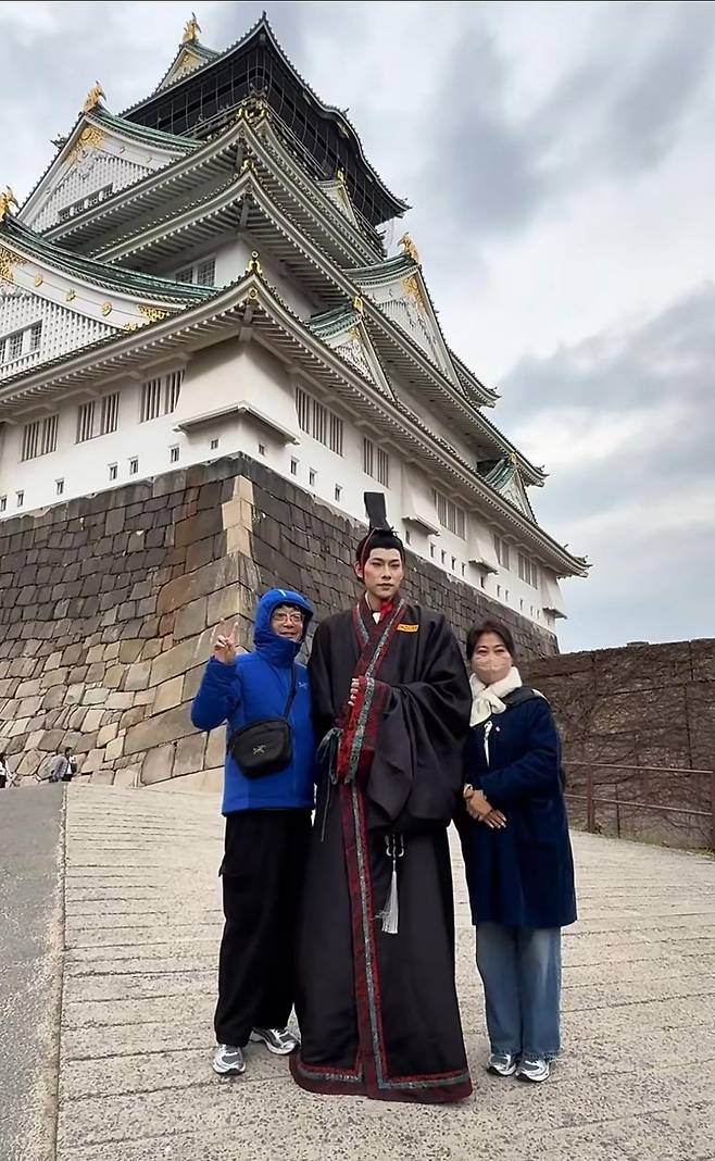 일본 오사카성에서 관광객과 기념 촬영을 하는 중국인 남성 인플루언서 [SNS 캡처]