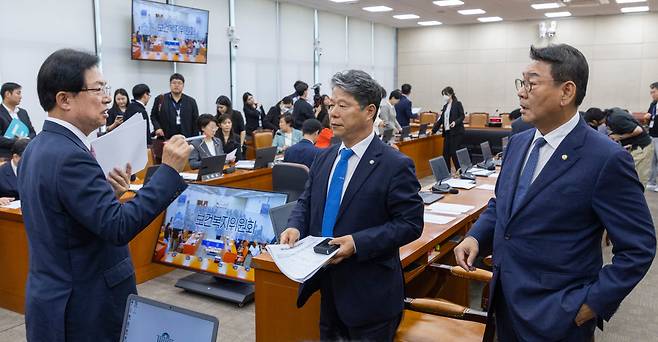 28일 국회에서 열린 보건복지위원회 전체회의에서 여야 의원들이 대화하고 있다. 왼쪽부터 위원장인 이만희 국민의힘 의원, 여당 간사인 서영석 더불어민주당 의원, 김교흥 민주당 의원. 여야는 국정감사에서 김승원 민주당 의원의 ‘코로나 신약 로비’ 의혹 관련자들을 증인으로 부를지를 두고 충돌했다. /연합뉴스
