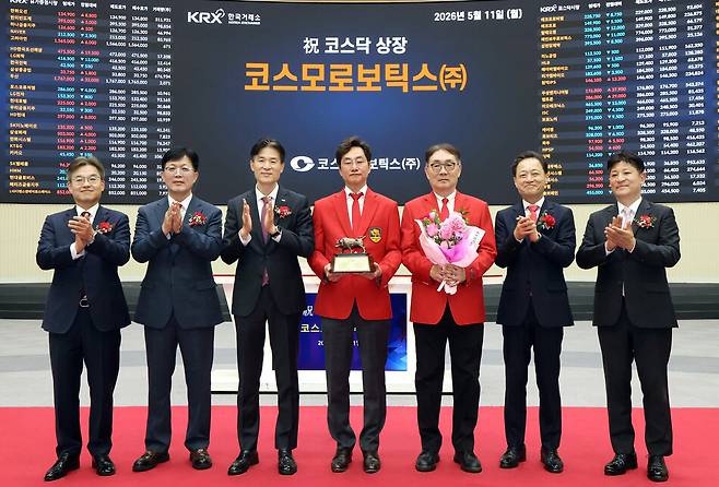 지난 5월11일 코스모로보틱스 코스닥 상장을 기념하며 오주영(왼쪽 네번째) 코스모로보틱스 대표이사와 강곤(왼쪽 다섯번째) 전 코스모로보틱스 대표이사가 기념 사진을 촬영하고 있다. 한국거래소 제공
