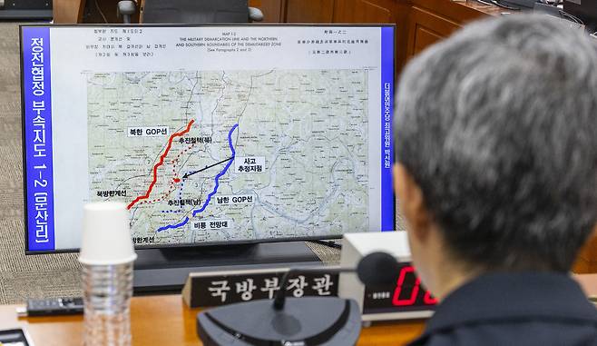 강신철 국방부 장관이 지난 29일 국회 국방위원회에서 열린 DMZ 지뢰 추정 폭발사고 현안 질의에 참석해 DMZ 사고 관련 의원 질의 도중 제시한 사고 지역의 지도를 바라보고 있다. 연합뉴스