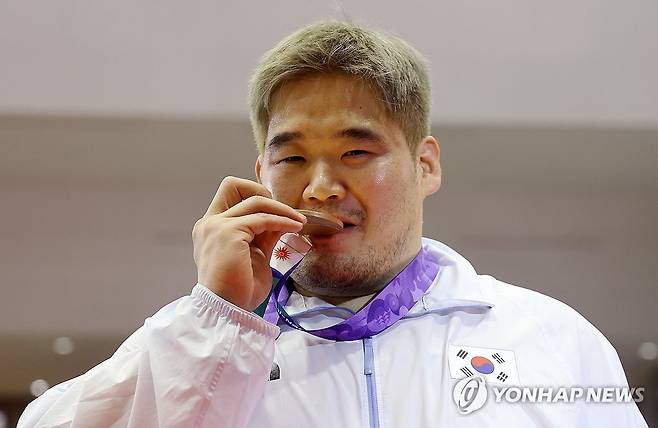 AG 연속 메달 차지한 김민석 '값진 동메달' (나고야=연합뉴스) 이동해 기자 = 30일 일본 나고야 이나에 스포츠센터에서 열린 2026 아이치·나고야 아시안게임 레슬링 남자 그로코로만형 130kg급에서 동메달을 차지한 김민석이 메달을 깨물고 있다. 2026.9.30 eastsea@yna.co.kr