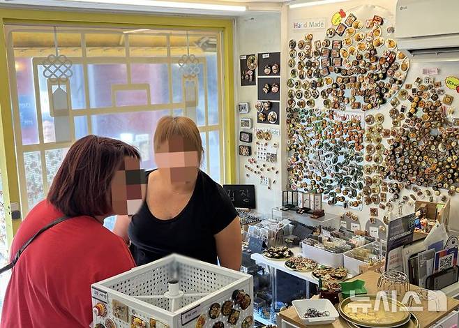 [서울=뉴시스] 진민아 인턴기자 = 30일 서울 종로구 '마그나라'에서 외국인 관광객들이 K푸드 미니어처 마그넷을 둘러보고 있다.2026.09.30.