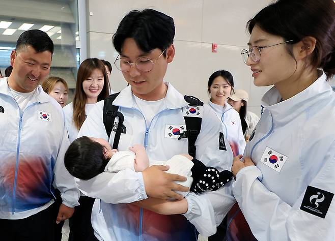 韓양궁 자존심 지킨 이우석 “아빠 금메달 두 개 땄어” 2026 아이치·나고야 아시안게임에서 양궁 남자 리커브 개인전과 단체전 2관왕에 오른 이우석(가운데)이 4일 오후 인천국제공항을 통해 귀국한 뒤 태어난 지 석달 된 아들 도윤이를 안고 미소짓고 있다. 인천공항=뉴스1