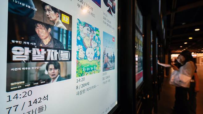 왜곡 논란의 영화 '암살자(들)'이 200만 돌파에도 불구하고 다시 박스오피스 2위로 하락했다. 1위는 일본 천만 애니 '극장판 치이카와: 인어섬의 비밀'이 차지했다. 사진은 서울 한 영화관의 티켓 발권기 앞에서 영화를 고르고 있는 관객들./뉴스1