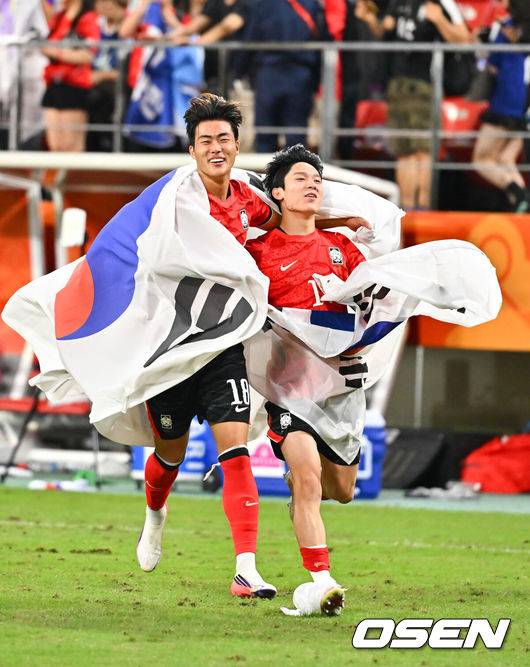[OSEN=도요타(일본), 박준형 기자] 미쳤다! 엄지성(24, 스완지 시티)이 결승골로 한국축구를 살렸다.&nbsp;이민성 감독이 이끄는 U23 남자축구대표팀은 3일 오후 7시 30분 도요타 스타디움에서 개최된 아이치-나고야 아시안게임 2026 결승전에서 엄지성의 결승골이 터져 숙적 일본을 1-0으로 제압했다.&nbsp;경기종료 후 김명준과 양민혁이 태극기를 들고 그라운드를 돌고 있다.   2026.10.03 /  soul1014@osen.co.kr