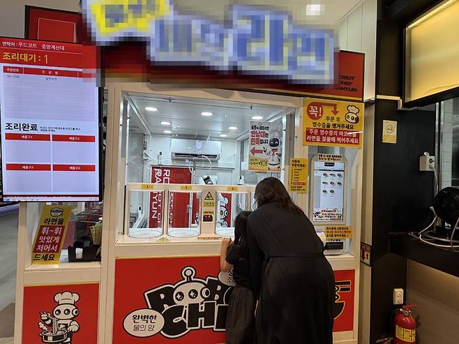 가평휴게소에서 라면 로봇을 구경하는 가족 단위 이용객. 연합뉴스