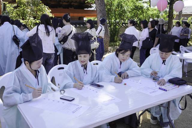 백일장 본 경연에 참가한 외국인 주민들이 밝은 표정으로 도화지와 원고지에 글을 써 내려가며 소통하고 있다. 달서구가족센터 제공