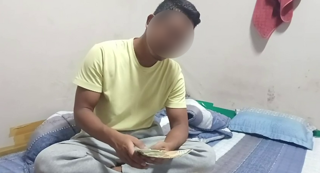 ▲ 경남 밀양에서 고용허가제(E-9)로 일하는 네팔 이주노동자 A씨가 계약해지를 대가로 사업주에게 전달할 돈을 세고 있다. <이주노조 제공 영상 갈무리>