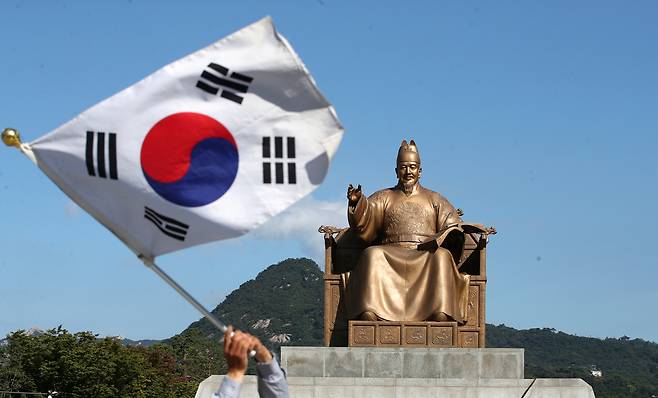 서울 세종대로 광화문광장 세종대왕 동상 앞에서 한 시민이 태극기를 흔들고 있다.  뉴스1