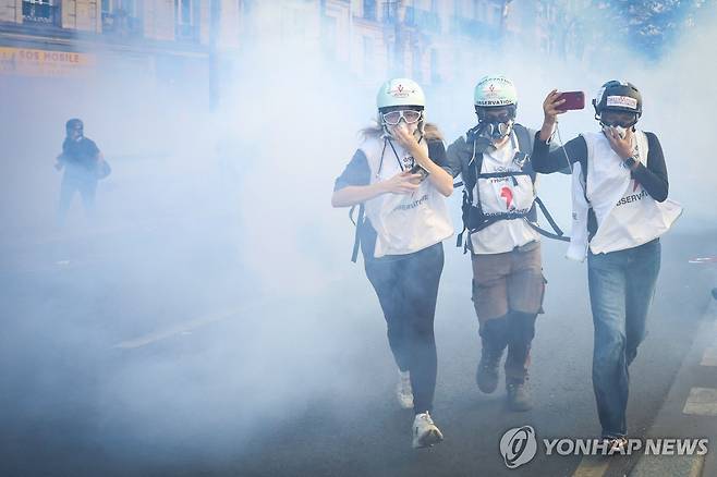 파리 학생 시위 현장에서 인권단체 옵서버들이 최루가스 사이로 뛰어가고 있다 [AFP=연합뉴스. 재판매 및 DB 금지]