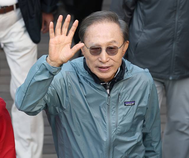 이명박 전 대통령이 8일 서울 청계천에서 ‘청계천을 사랑하는 모임’(청사모) 구성원들과 청계천을 걸으며 손을 흔들고 있다. 연합뉴스