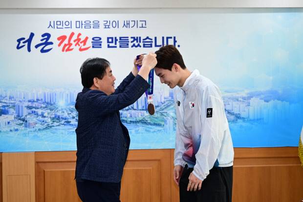 배낙호 김천시장이 2026 아이치·나고야 아시안게임 배드민턴 남자단식에서 동메달을 획득한 김천시청 소속 유태빈 선수에게 메달을 걸어주고 있다. 김천시 제공