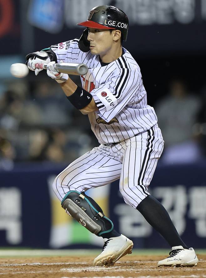 14일 서울 잠실야구장에서 열린 LG 트윈스와 두산 베어스의 2026 신한 SOL KBO 포스트시즌 와일드카드 결정전 1차전. 8회말 1사 1,3루 LG 신민재가 번트를 하고 있다. <저작권자 ⓒ 1980~2026 ㈜연합뉴스. 무단 전재 재배포 금지, AI 학습 및 활용 금지>