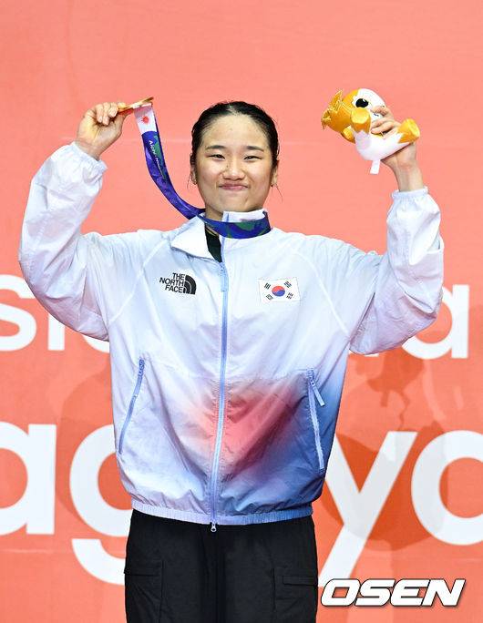 [OSEN=아이치현(일본), 박준형 기자] 또 하나의 배드민턴 역사가 탄생했다.&nbsp;'셔틀콕 여제' 안세영(24, 삼성생명)이 최초의 아시안게임 여자 단식 2연패라는 대업을 이뤘다.안세영은 29일 일본 이치노미야 시립 체육관에서 열린&nbsp;2026년 아이치·나고야 아시안게임 배드민턴 여자 단식 결승전에서 야마구치 아카네(일본·세계 3위)를 2-0(21-17 21-9)로 격파하고 금메달을 차지했다. 결승전마저 휴식시간 총 52분 만에 2-0 완승으로 끝내며 '퍼펙트 우승'을 완성했다.시상식에서 안세영이 금메달을 들고 포즈를 취하고 있다.   2026.09.29 / soul1014@osen.co.kr