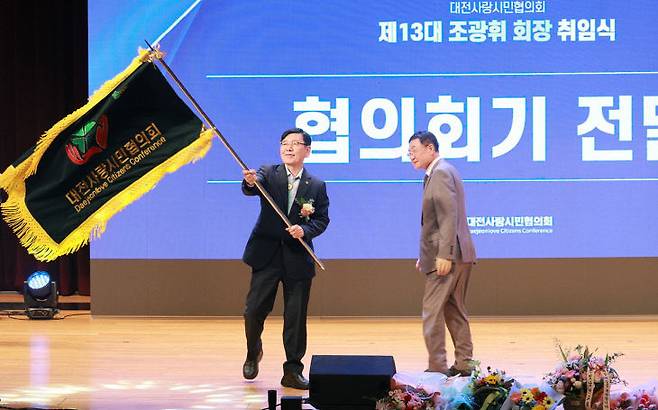 조광휘 신임 회장이 남재동 이임회장으로부터 협의회기를 전달받아 흔들고 있다.  사진=대전시 제공