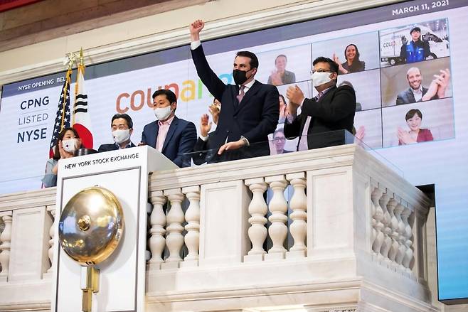 쿠팡 관계자들이 2021년 3월 11일 미국 뉴욕증권거래소(NYSE)에서 상장을 기념하고 있다. 쿠팡은 미국 자본시장에 상장된 기업에 대한 한국 정부의 규제가 한미 통상 문제로 확대된 사례로 거론된다. /쿠팡