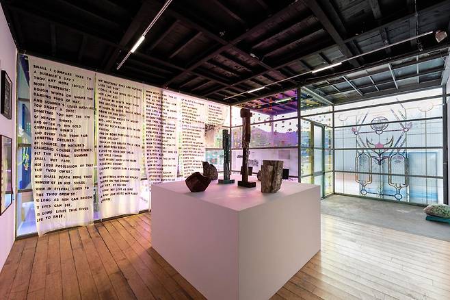 토탈미술관 개관 50주년 특별전 '한국미술 0년'에 조각가 김윤신의 나무·돌 조각을 중심으로 장지아의 소 피로 적은 사랑의 소네트와 듀킴의 스테인드글라스 도상으로 꾸민 창문 스티커 작품이 전시돼 있다. 토탈미술관 제공