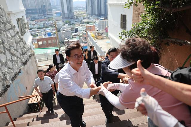 전재수(앞줄 왼쪽) 부산시장이 지난달 15일 부산 동구 산복도로 계단길에서 현장 소통에 나서며 주민들과 만나 인사를 나누고 있다. 부산시청 제공