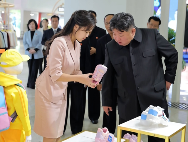 김정은 국무위원장이 지난 19일 ‘전국피복, 신발전시회-2026’을 찾아 딸 주애가 들어 보이는 분홍색 아동용 운동화를 살펴보고 있다. 조선중앙TV 연합뉴스
