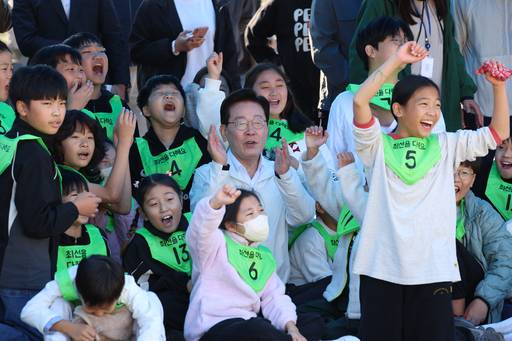 이재명 대통령이 22일 전북 익산 왕궁초에서 열린 가을 체육한마당에서 학생들과 응원을 하고 있다. /연합뉴스