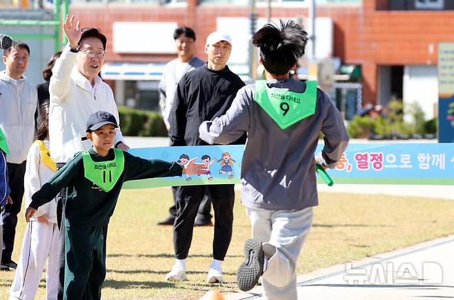 [익산=뉴시스] 김진아 기자 = 이재명 대통령이 22일 전북 익산 왕궁초등학교에서 열린 가을 행복학교 체육한마당에서 이어달리기 결승선 테이프를 잡고 학생들을 응원하고 있다. 2026.10.22. bluesoda@newsis.com