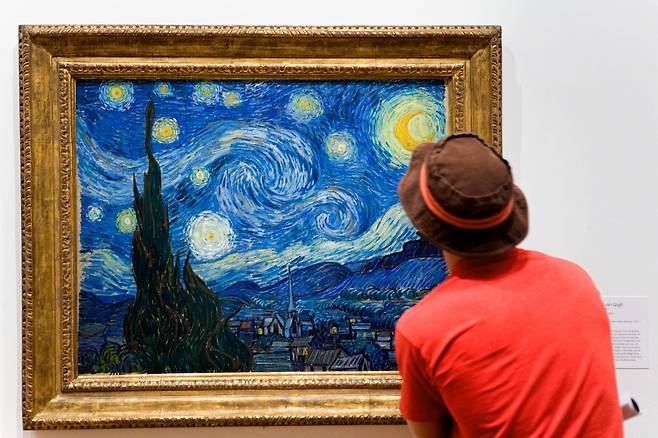 미국 뉴욕 현대미술관(MoMA)에서 관람객이 고흐의 '별이 빛나는 밤'을 보고 있다./Alamy