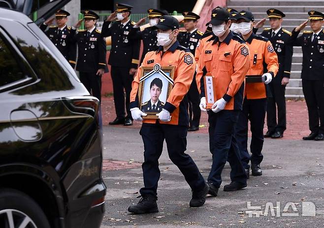 [부천=뉴시스] 전진환 기자 = 사진은 지난 19일 부천 공장 화재 진압 중 순직한 고(故) 김진석 소방위의 영정과 위패가 동료 소방대원들의 도열 속 경기도 부천체육관 영결식장을 나서고 있는 모습. (공동취재) 2026.10.19. photo@newsis.com