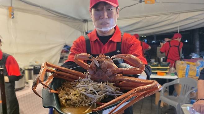 ▲ '2026 대구 떡볶이 페스티벌'에 등장한 속초 홍게 떡볶이 부스에서 상인이 홍게를 보여주고 있다. 김민규 기자